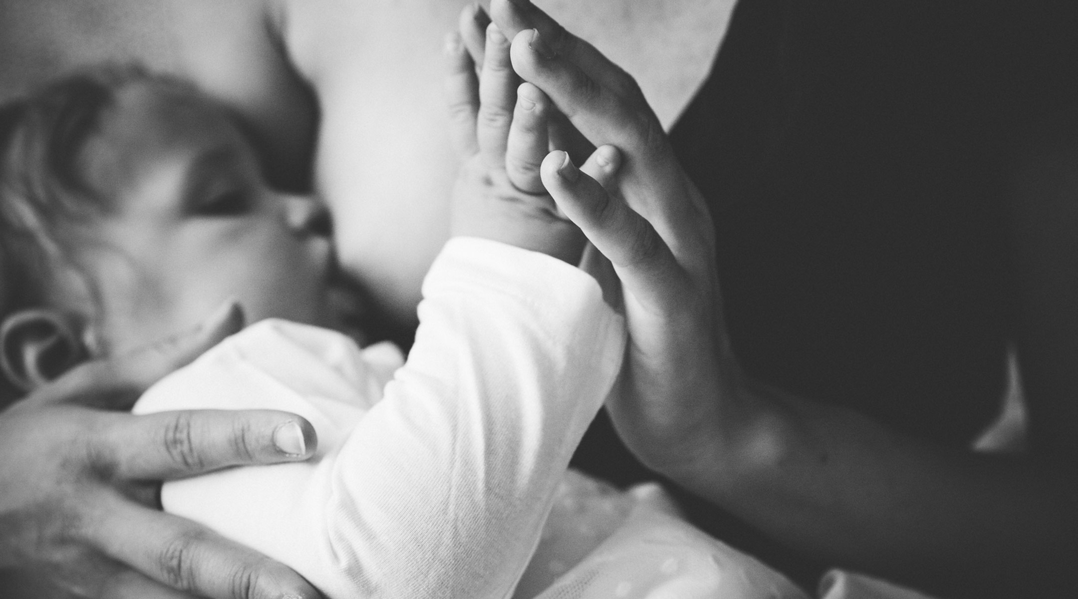 black and white image of mom bonding with baby while breastfeeding