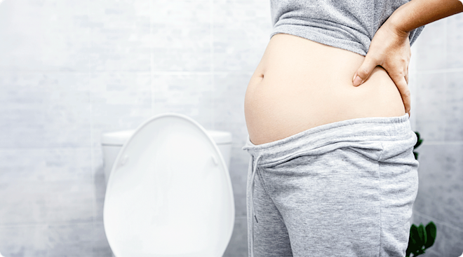 pregnant woman standing by toilet in bathroom