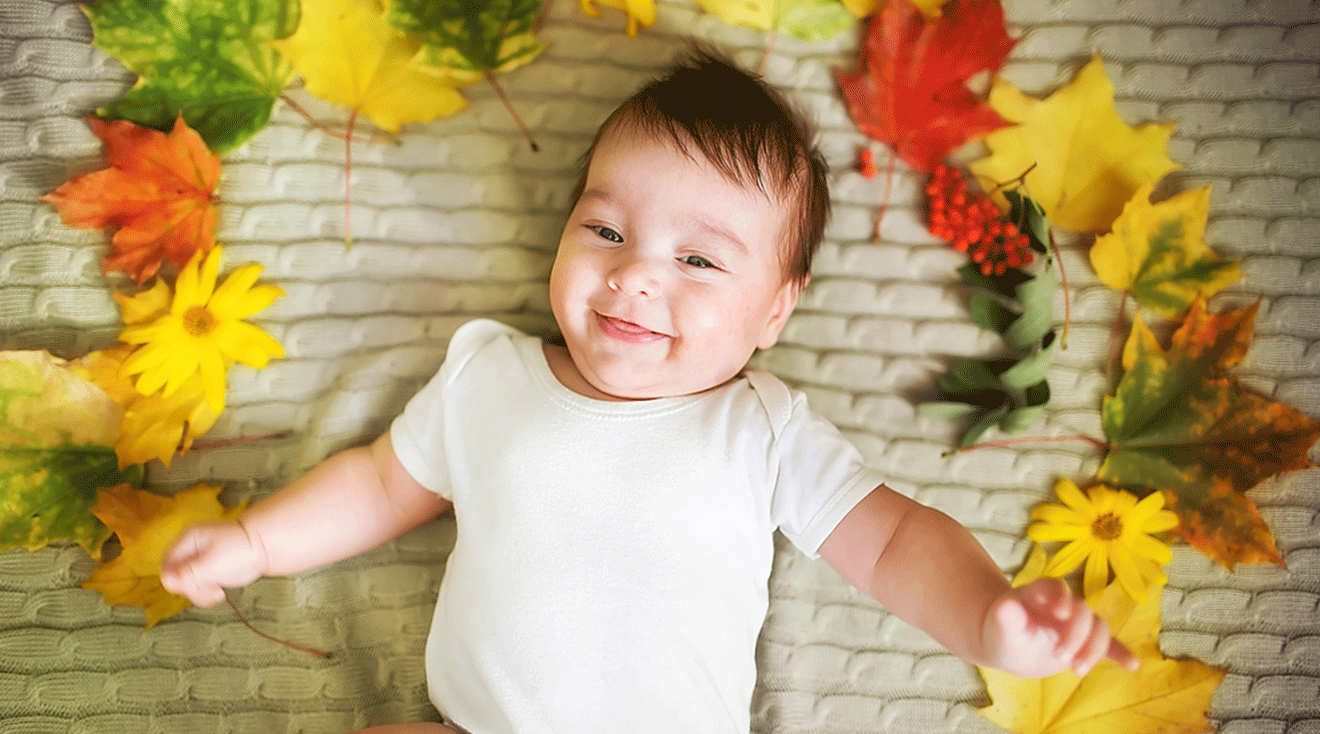 baby with autumn leaves