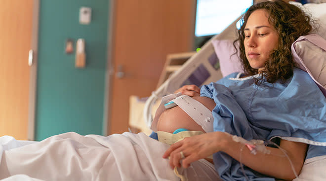 pregnant woman sitting in hospital bed while in labor