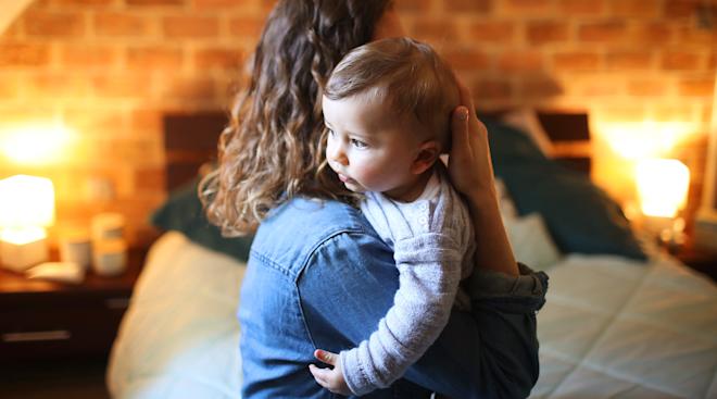 mom's face being hidden by her baby that she's carrying
