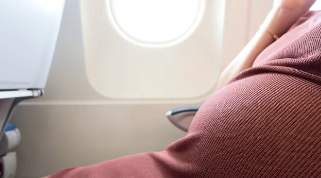 pregnant woman sitting on airplane