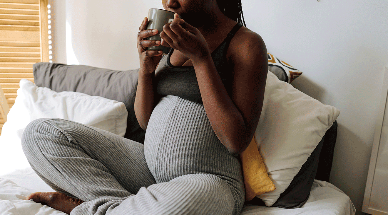 pregnant woman drinking from mug