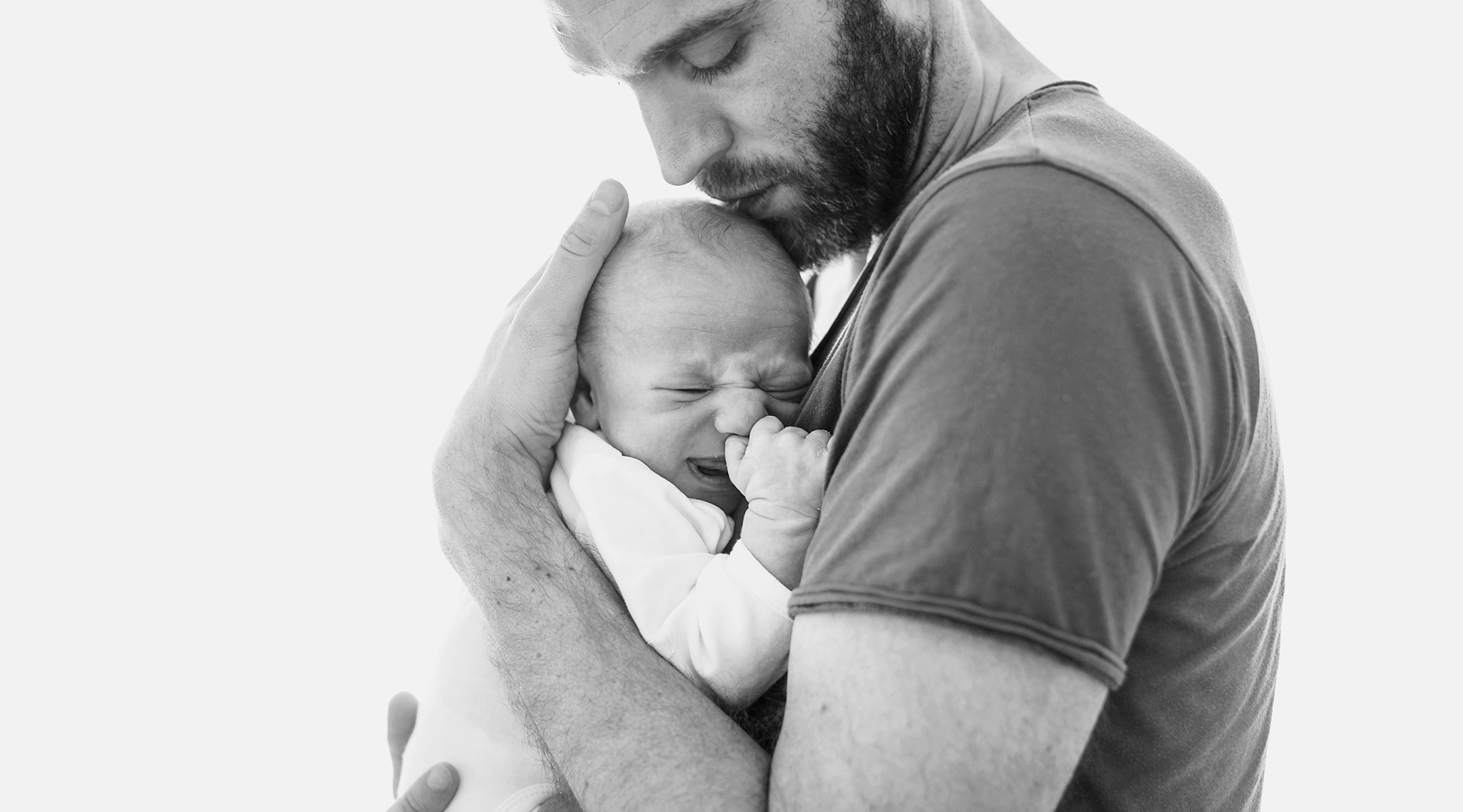 serious dad holding his newborn baby