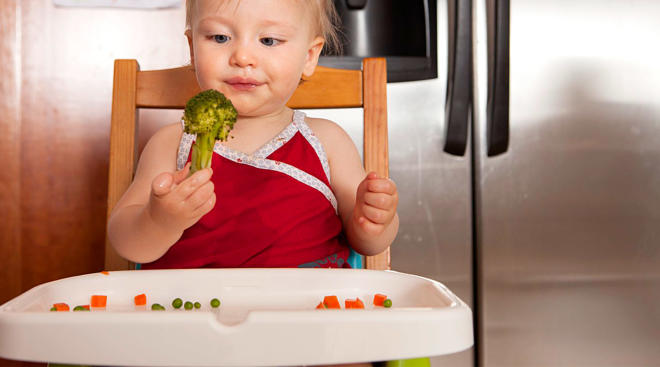 baby eating broccoli and maintaining variety in first foods