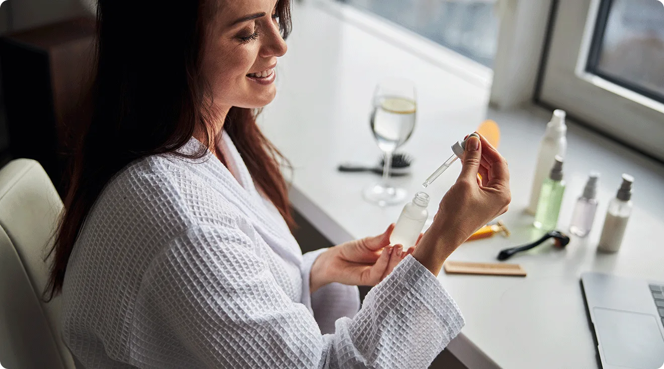 woman using skincare serum at home
