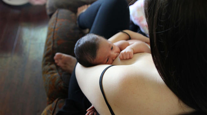 mom breastfeeding her newborn baby at home
