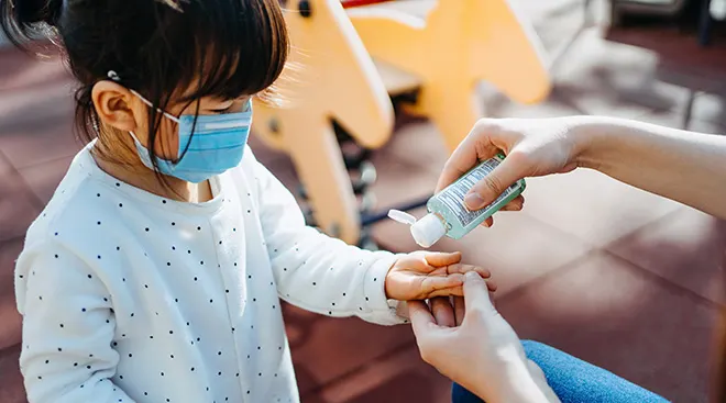 Mom applying hand sanitizer to child's hands