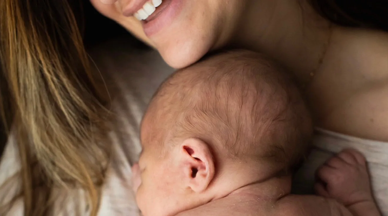 close up of smiling mother cuddling baby