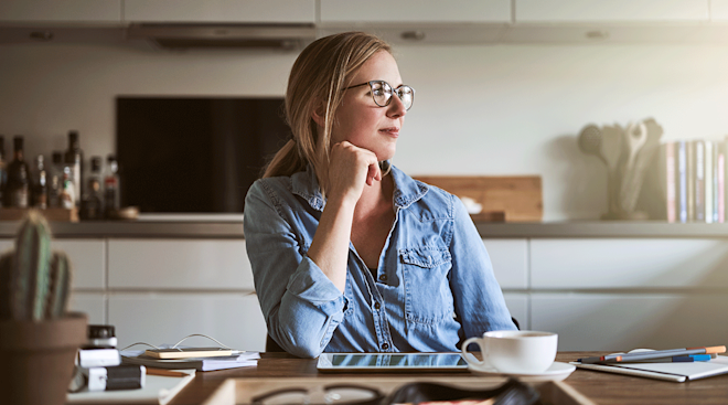 mom sitting at table at home thinking and pondering