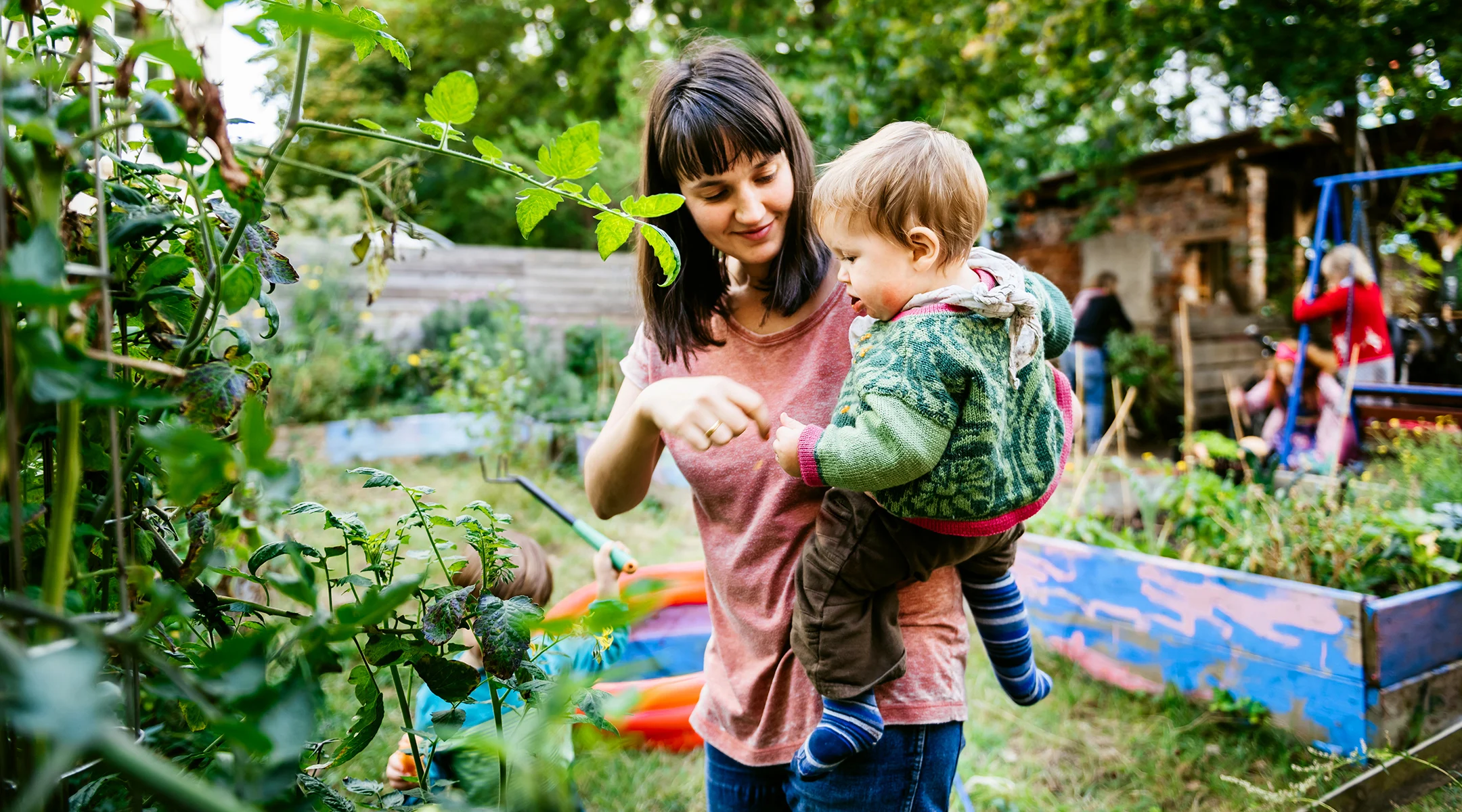 mom and toddler enjoying greenery in backyard 