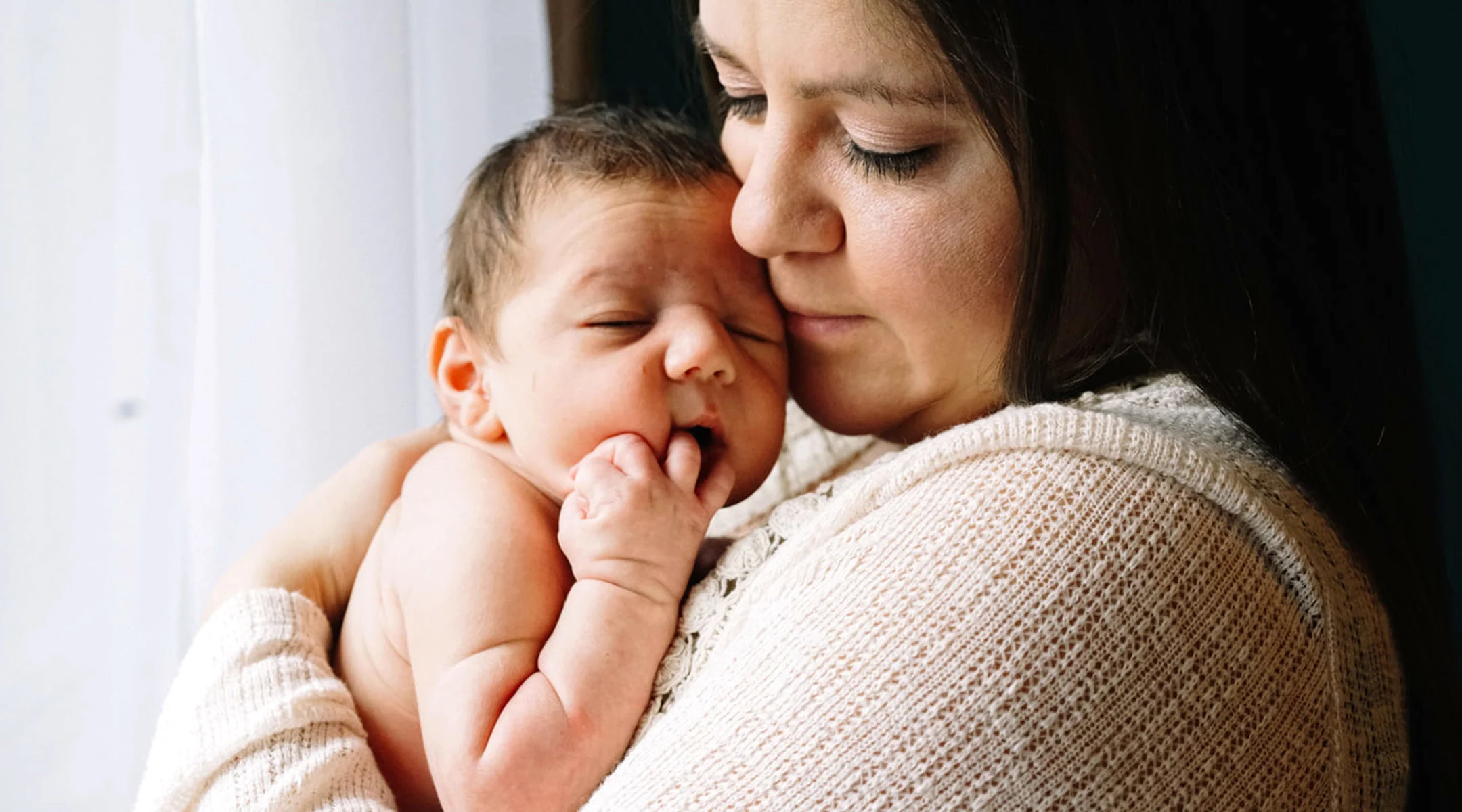 new mom holding her newborn close