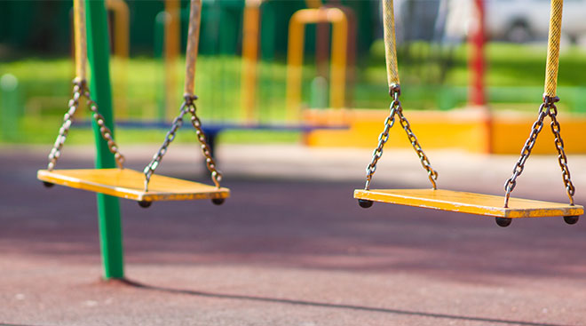empty yellow swings in playground