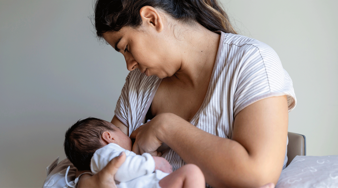 mother breastfeeding newborn baby at home