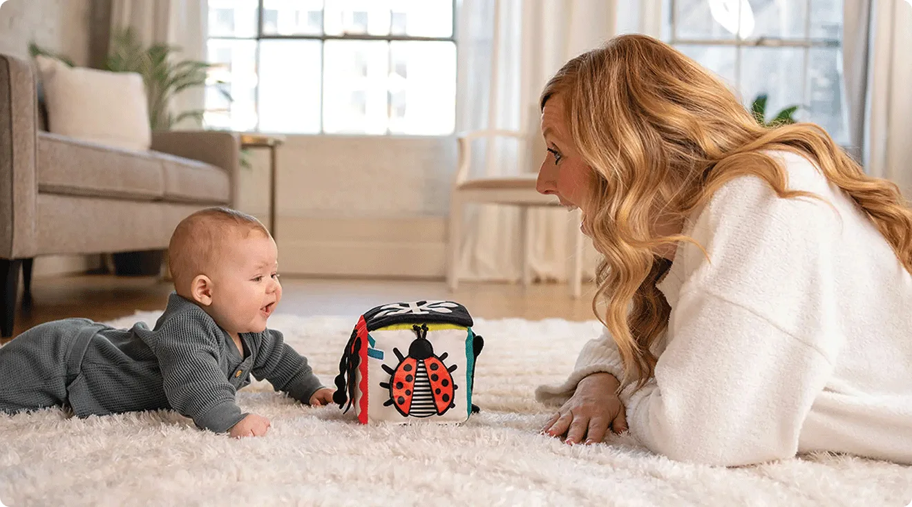 Mom and baby playing with the Manhattan Toy Sensory Cube