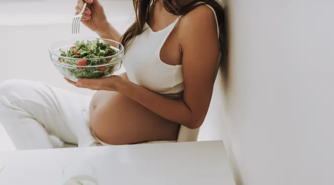 pregnant woman eating a salad