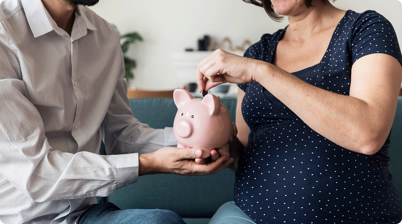 pregnant couple putting money into a piggy bank