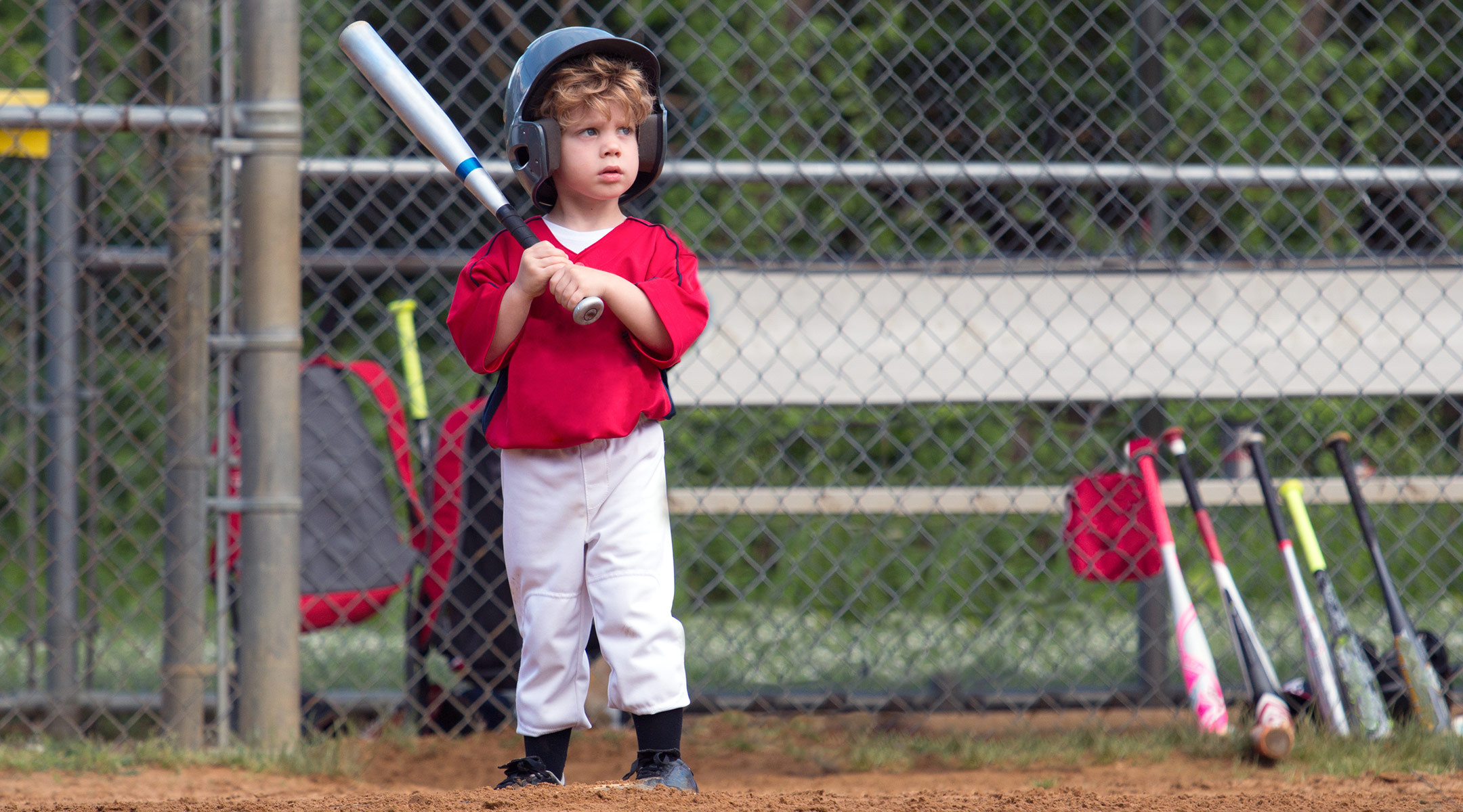 small child playing baseball at bat