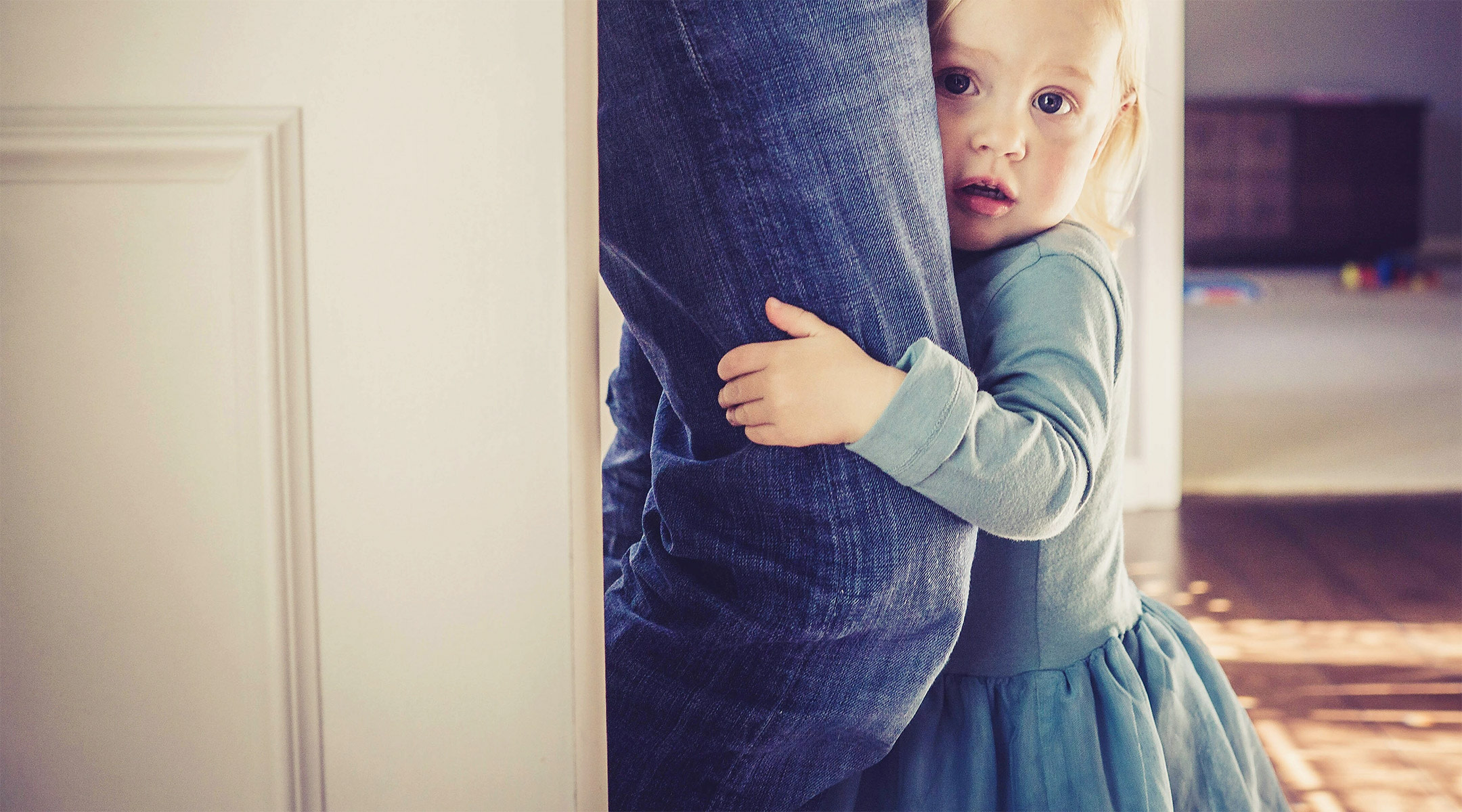 little girl separation anxiety holding parent leg
