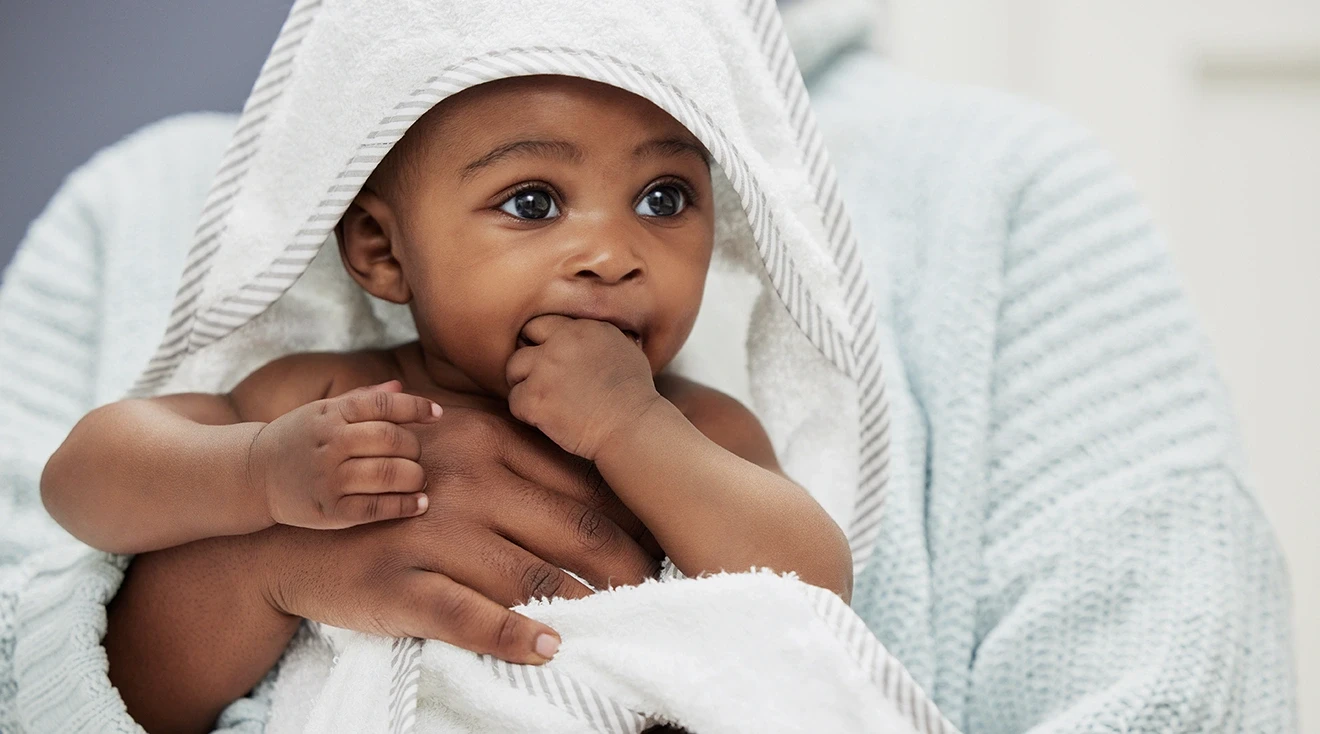 clean baby in towel after bath