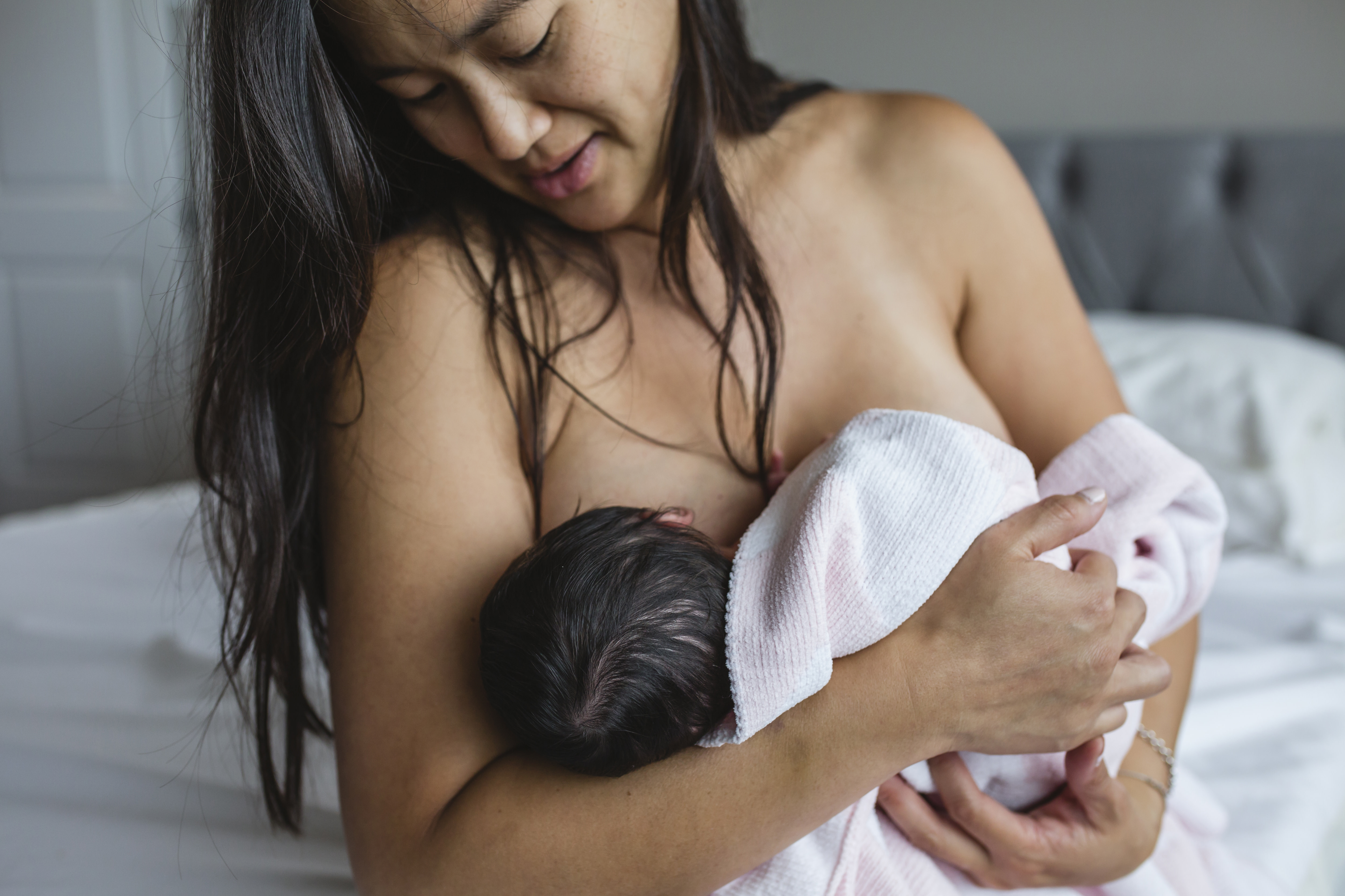 mom struggling to breastfeed her baby