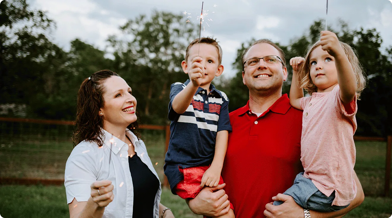 family holding sparklers on the fourth of july
