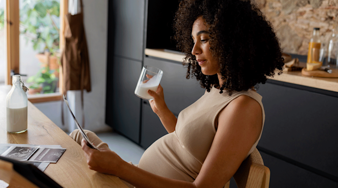 pregnant woman drinking a glass of milk