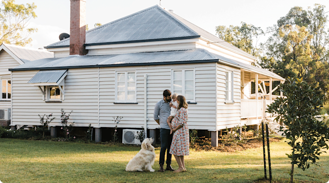 loving family with toddler and pregnant mom outside of their home