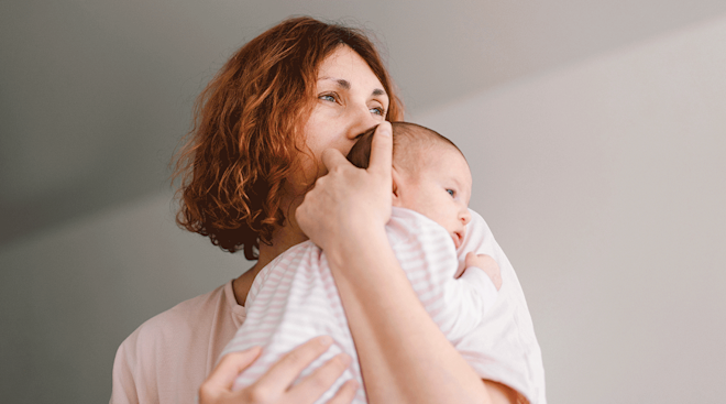 mother holding newborn baby at home