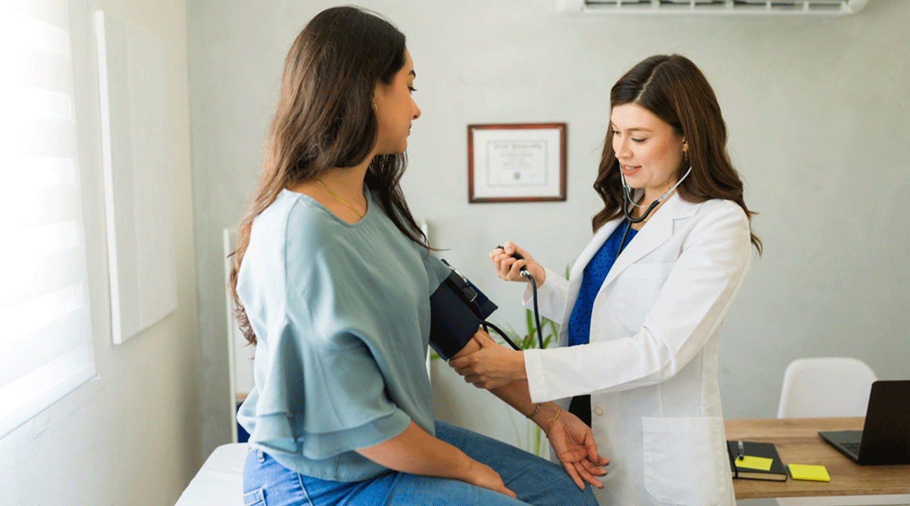 woman getting blood pressure measured by doctor