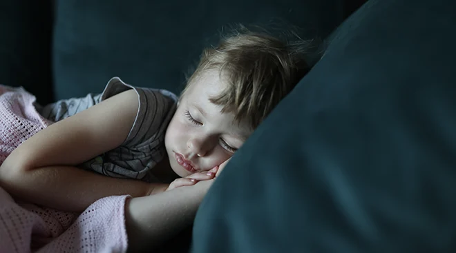 young girl sleeping on couch at home