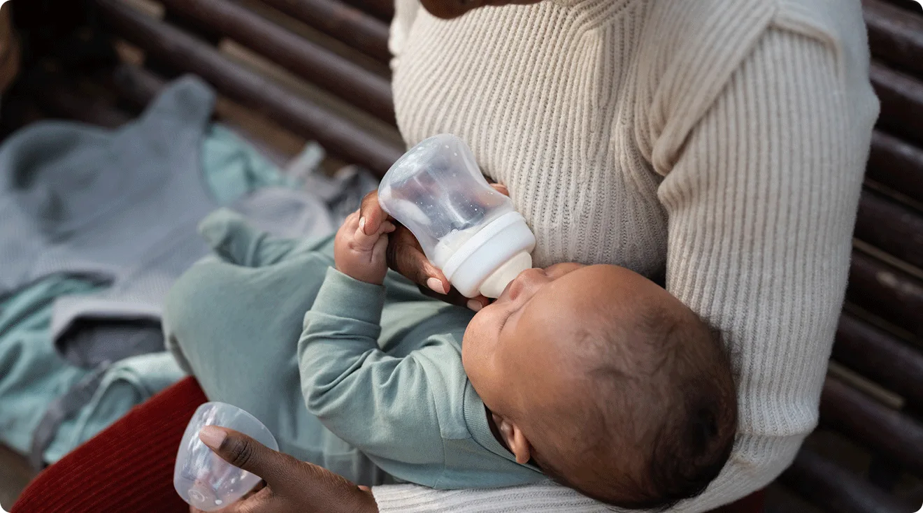 mom giving a bottle to baby