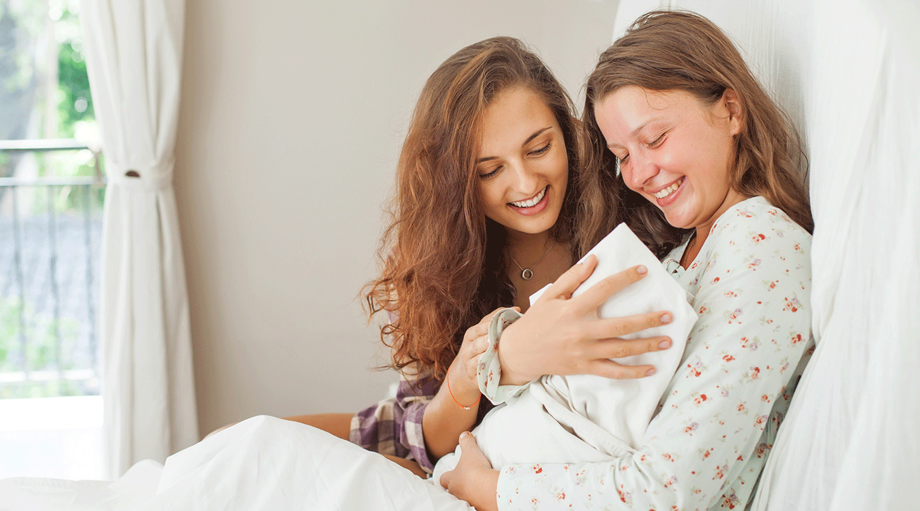 woman meeting friend's newborn baby at home