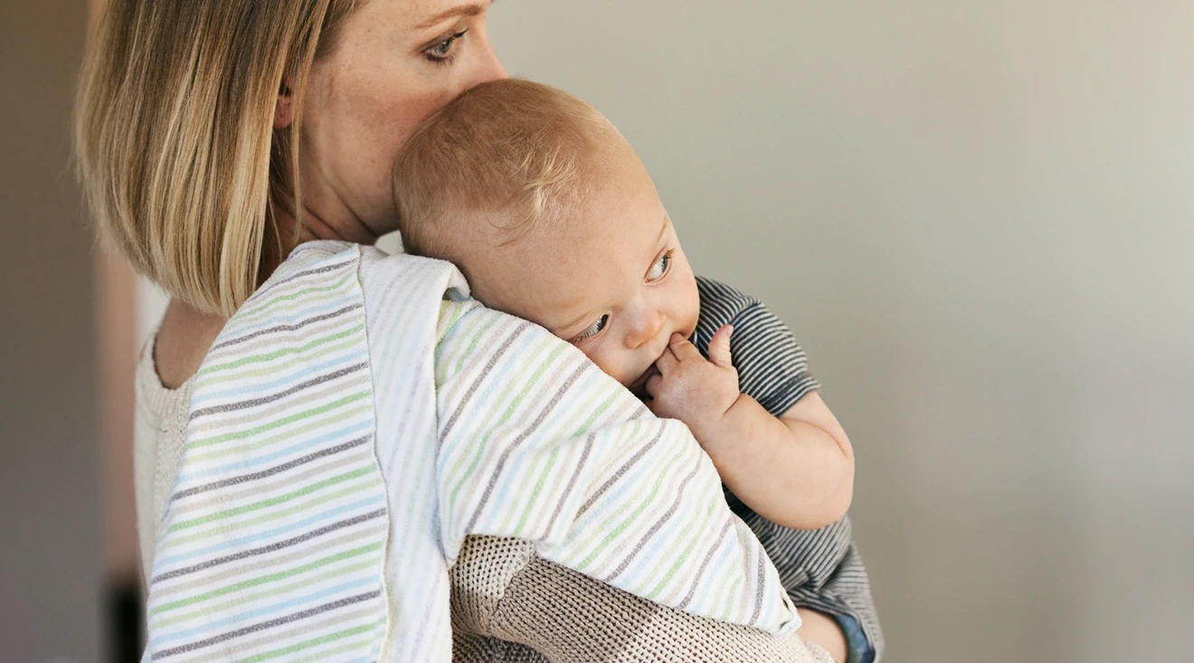 lonely mother holding baby at home