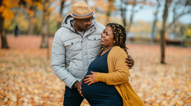 pregnant couple outside in autumn