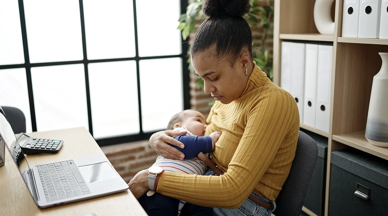 mother breastfeeding baby while working
