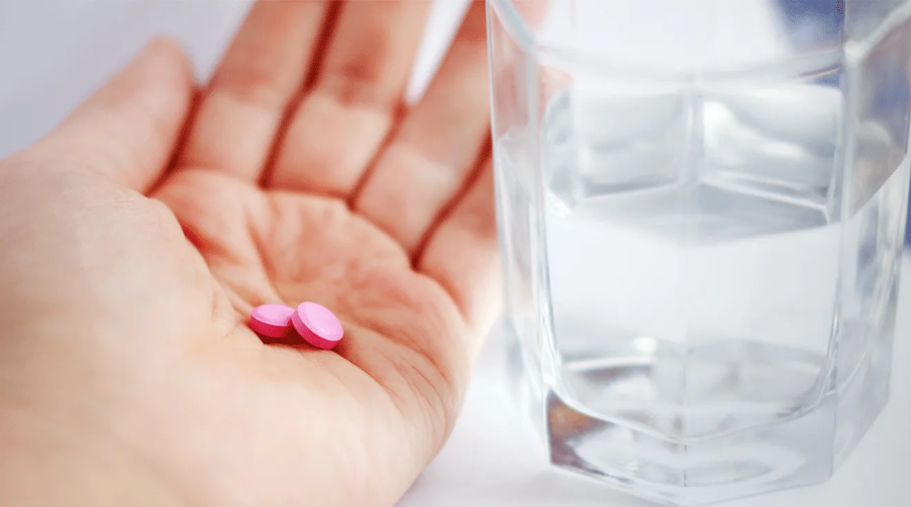 pink allergy pills in woman's hand