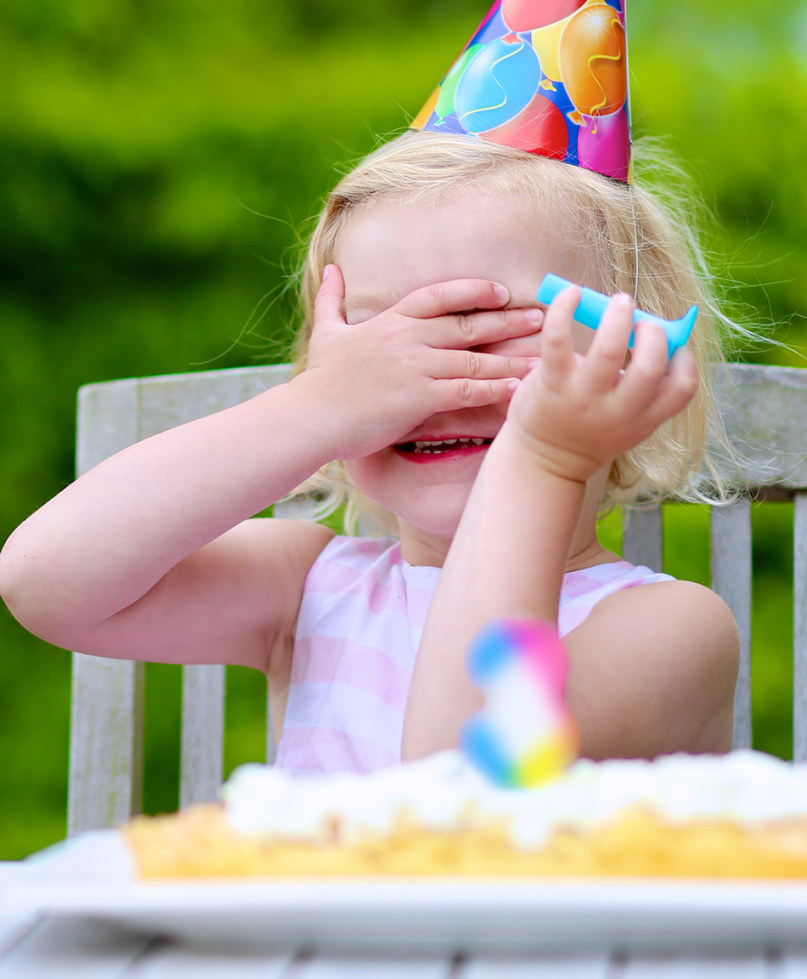toddler birthday girl covering her face with her hands
