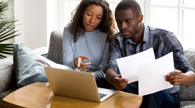 couple looking at bills on laptop together