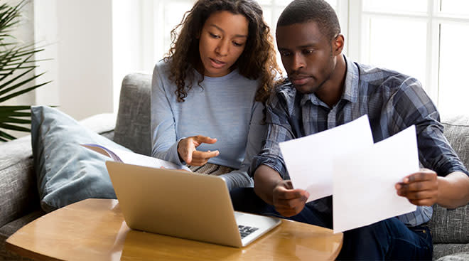 couple looking at bills on laptop together