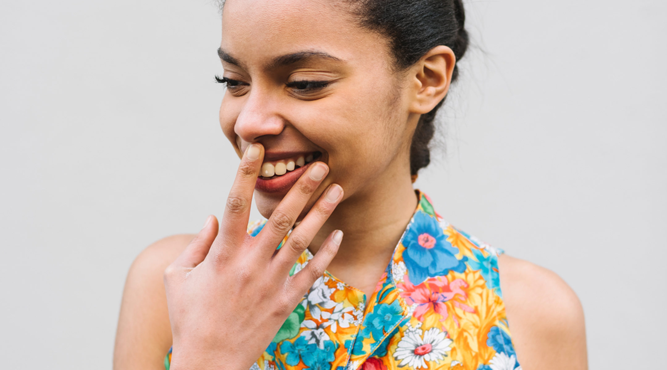 woman smiling laughing hand over mouth