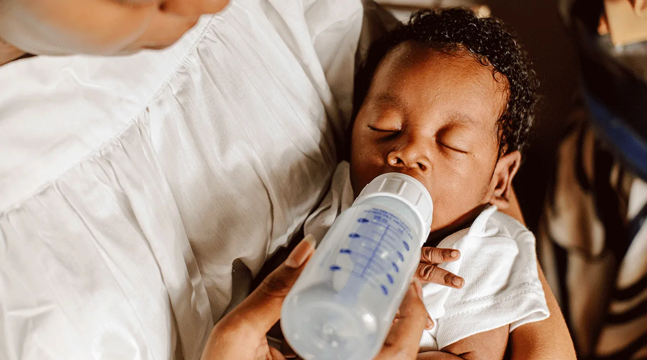mother giving newborn baby a bottle