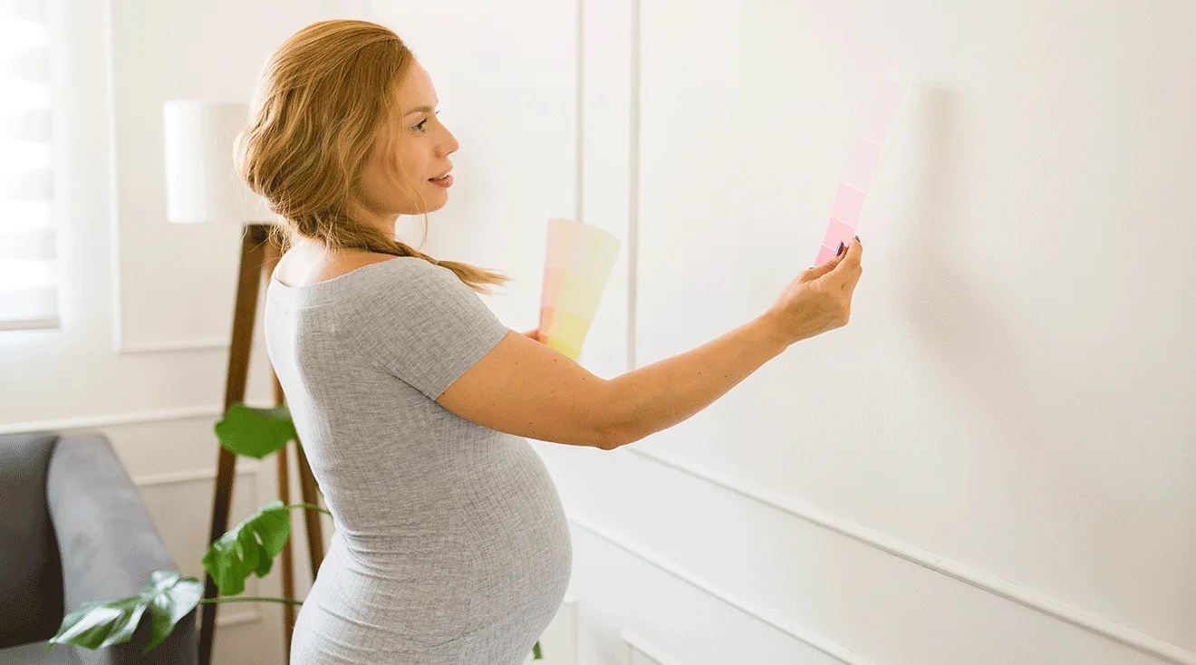 pregnant woman choosing paint color for nursery walls