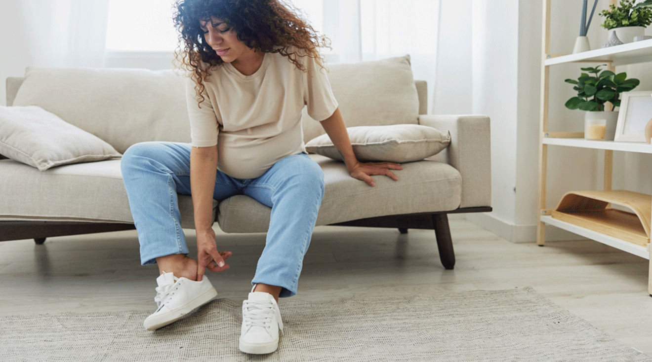 pregnant woman putting on sneakers