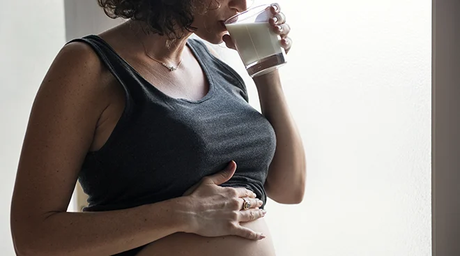pregnant woman drinking a glass of milk