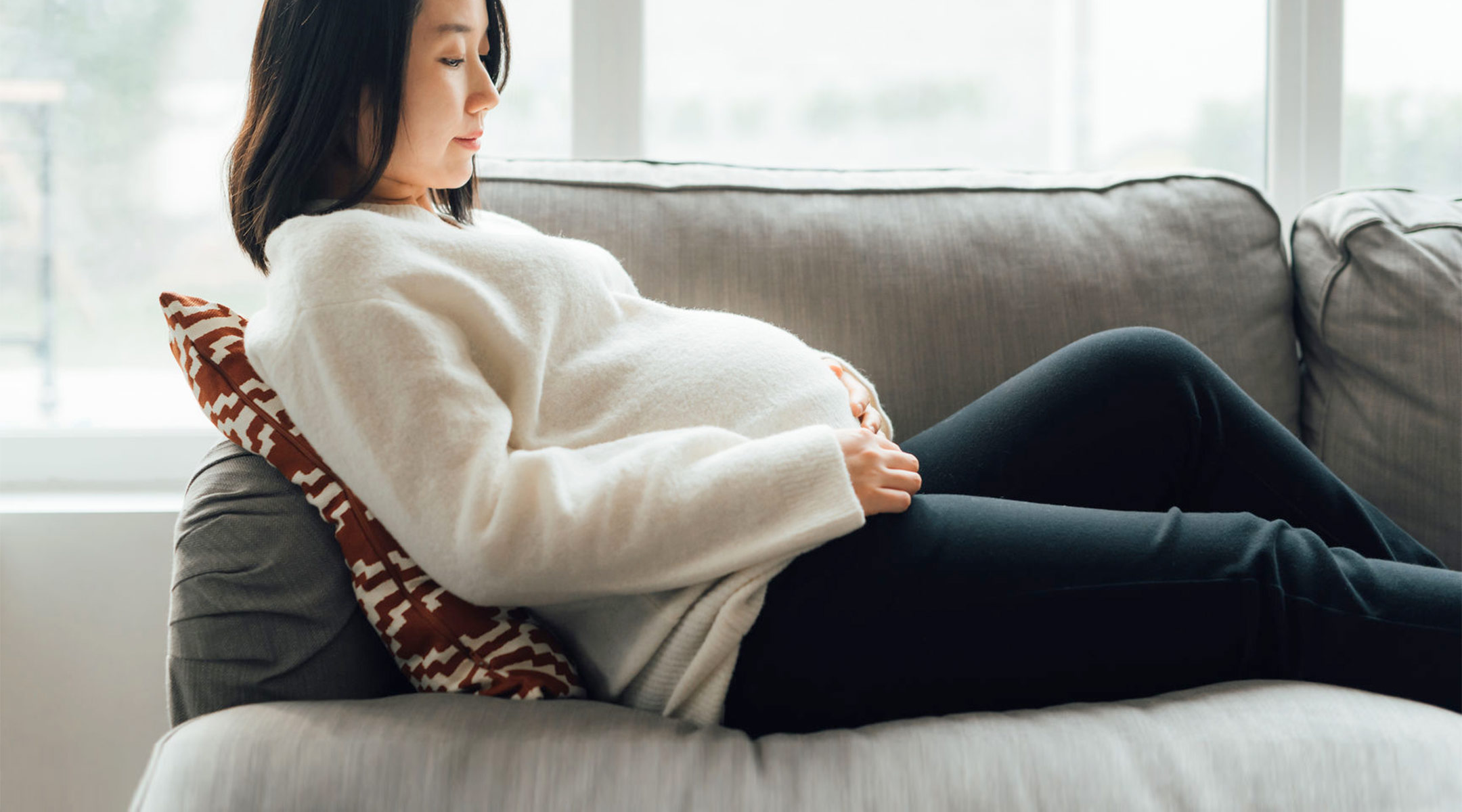 pregnant woman propped up on the couch