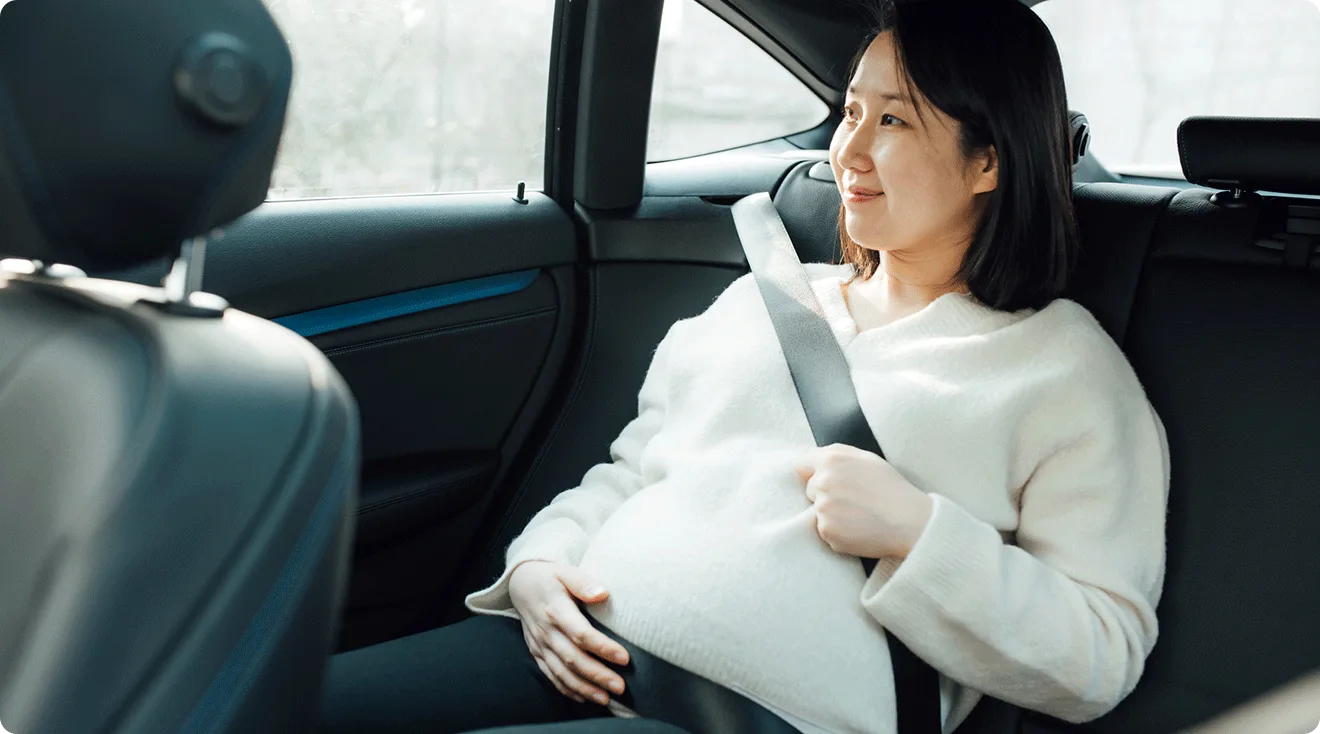 pregnant woman sitting in the back seat of a car