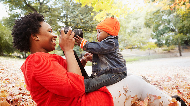 mom taking photos of her baby during the fall season
