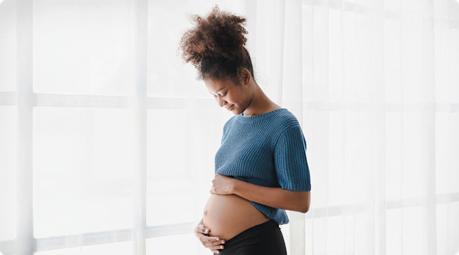 pregnant woman looking down at belly