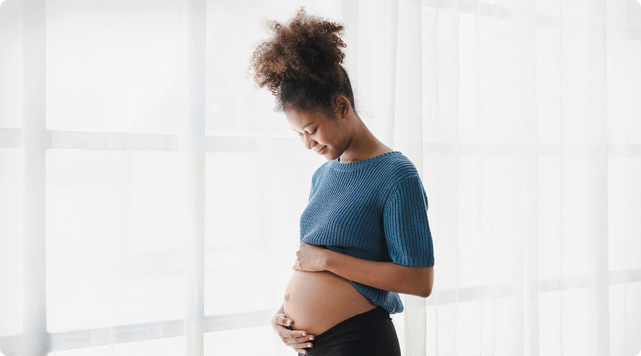 pregnant woman looking down at belly